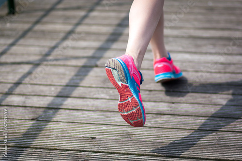  Young women jogging at wooden bridge . Close-up photo of her legs