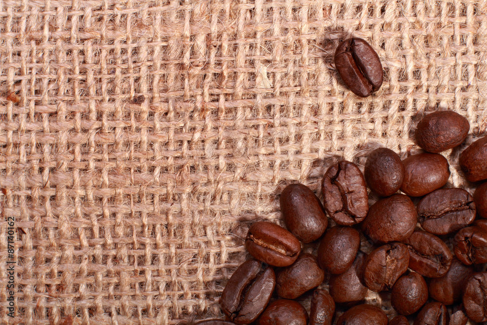 Roasted coffee beans on burlap background Roasted coffee beans on burlap background