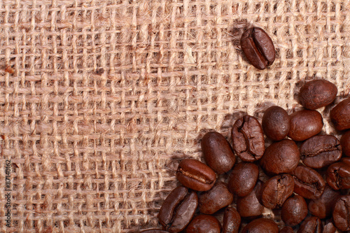 Roasted coffee beans on burlap background