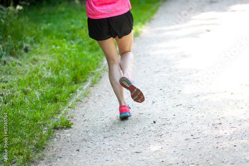  Young women jogging at park . Close-up photo of her legs