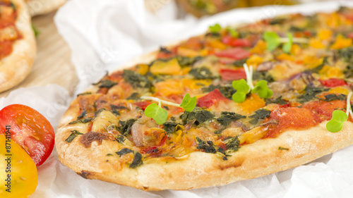 Veggie Pizza - Vegetarian mini pizza on a wooden background.