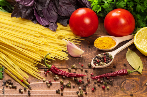 Raw pasta  vegetables  basil and spices on the wood table