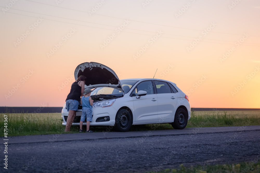 Fototapeta premium Mom with Son Opening the Front of Defective Car