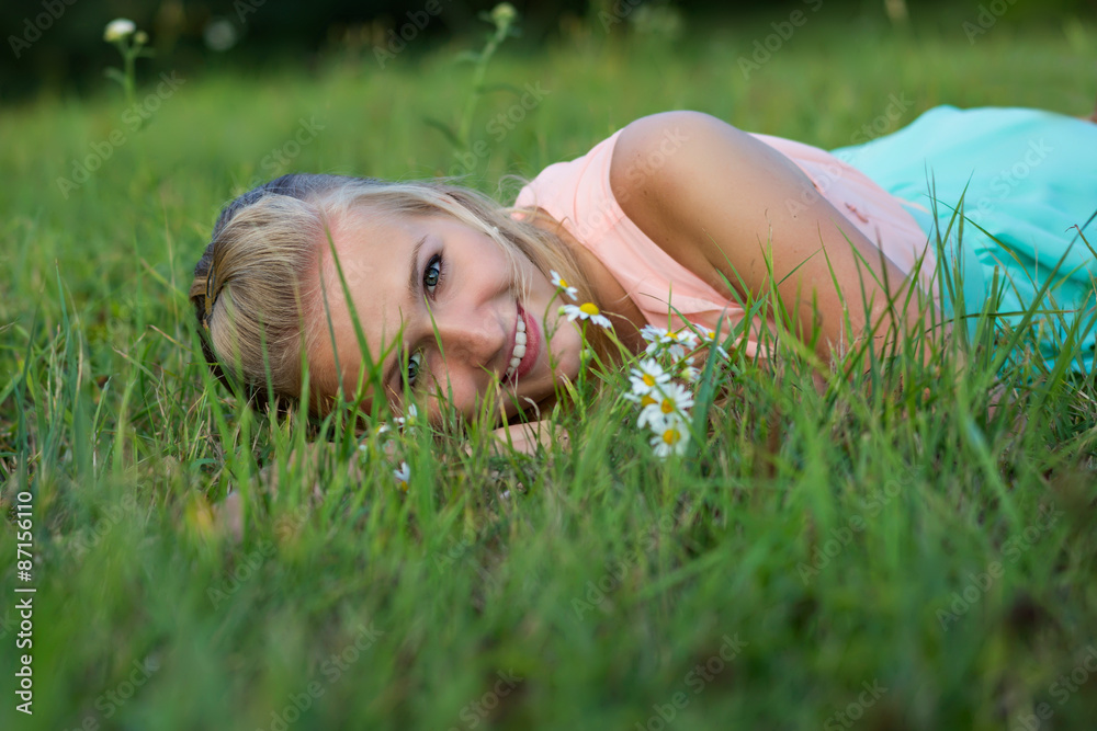 A happy laughing young woman laying on the grass A happy laughing young woman laying on the grass