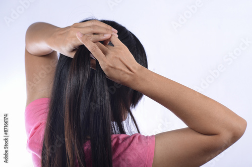Asian woman braiding hair.