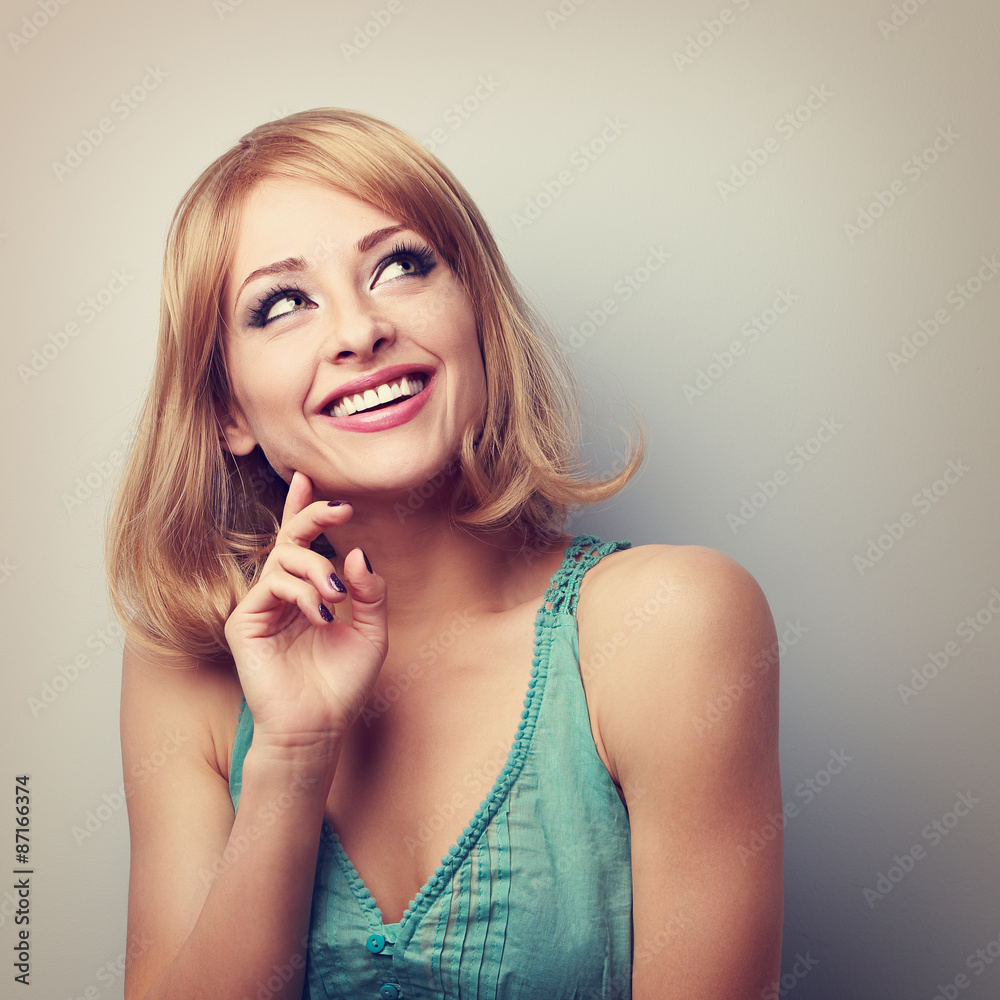 Happy toothy smiling blond woman thinking and looking up. Toned
