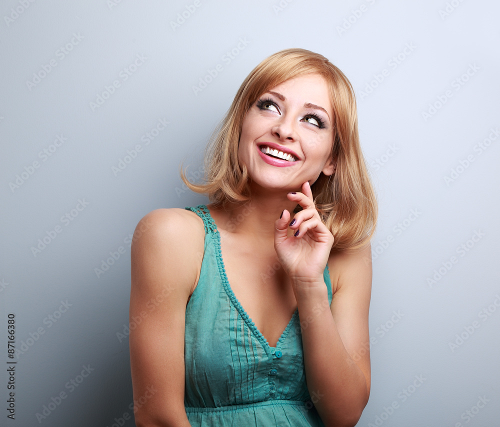 Happy toothy smiling blond woman thinking and looking up Happy toothy smiling blond woman thinking and looking up