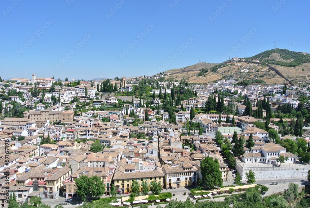 Panoramic view on the Andalusian city of Granada from the top of Alhambra complex, on a sunny summer day.