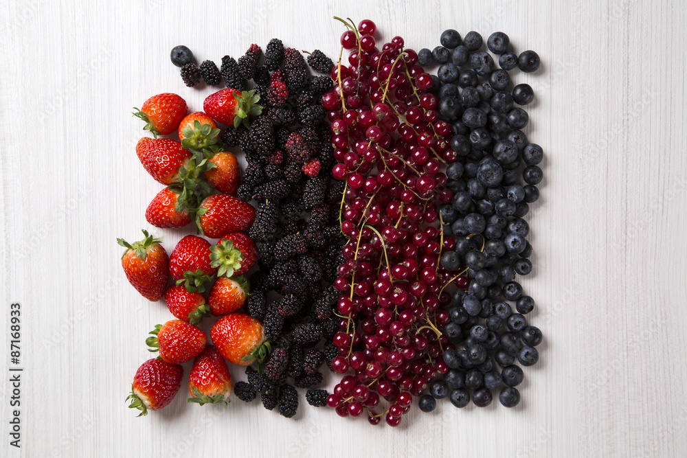 Some gooseberries, raspberries, strawberries and blueberries ove Some gooseberries, raspberries, strawberries and blueberries ove