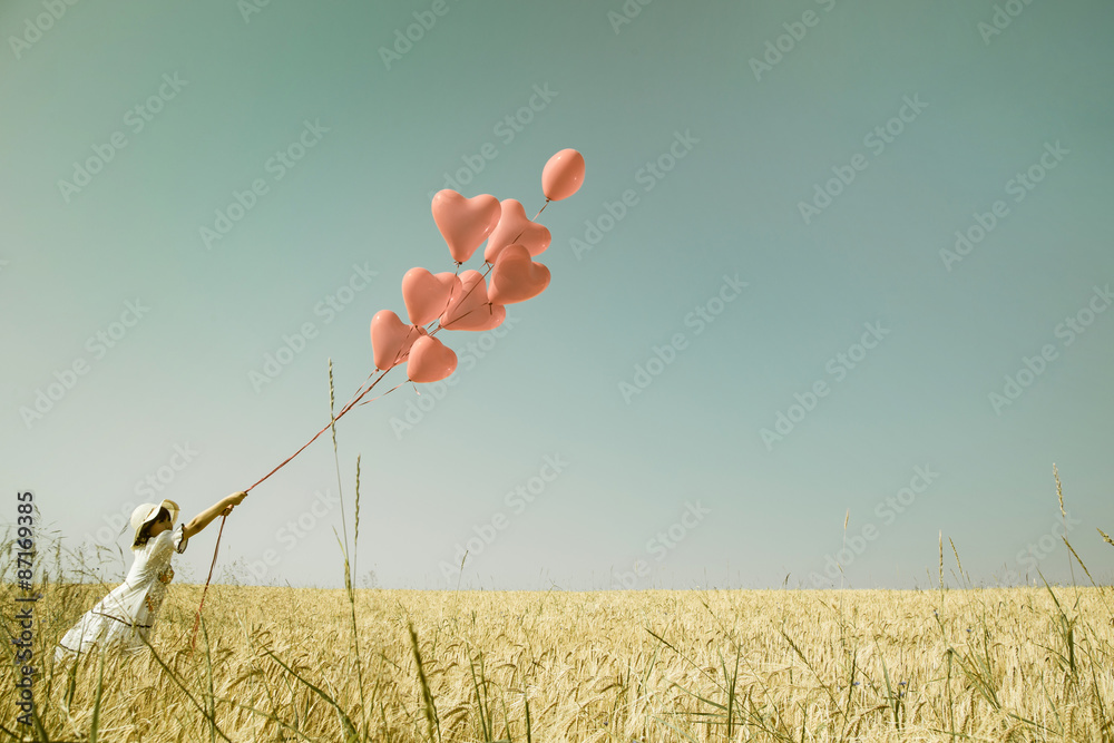 Konzept für Liebe, Freiheit, Mut. Hintergrund mit roten Luftballons und einem Mädchen im Sommer  - obrazy, fototapety, plakaty 