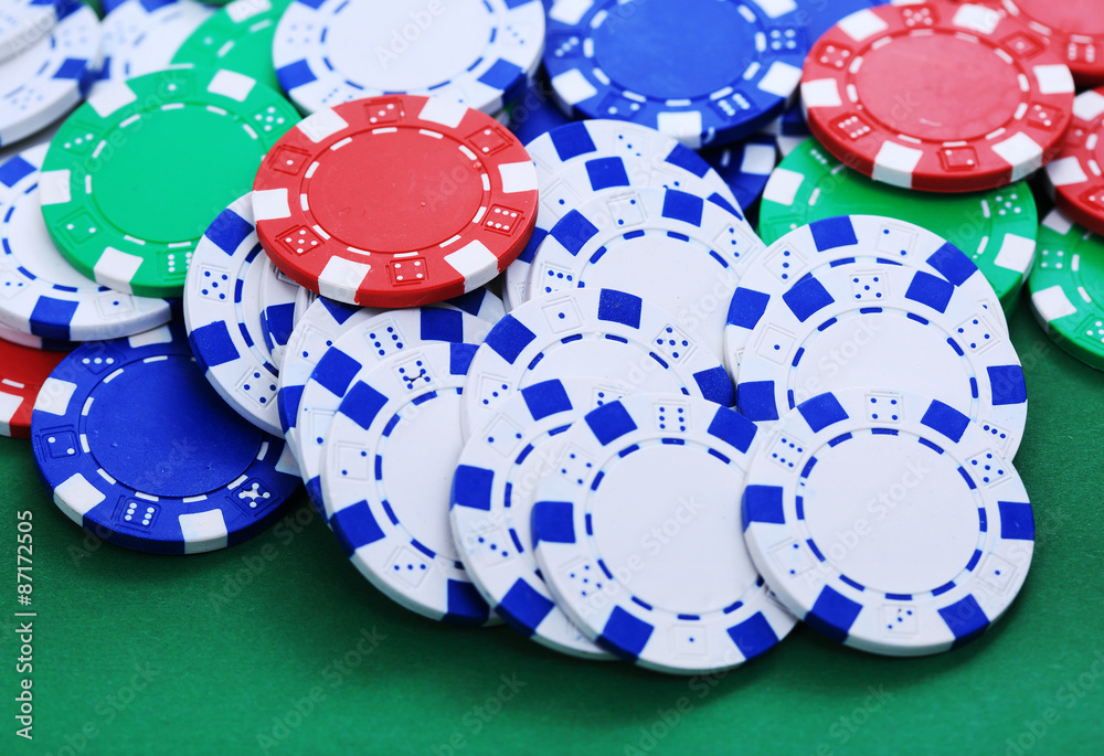 Colorful tokens in casino on green background Colorful tokens in casino on green background