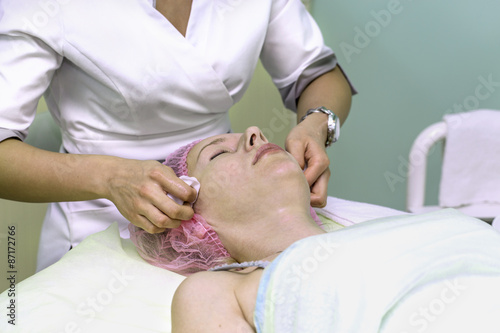 Cosmetician cleaning face