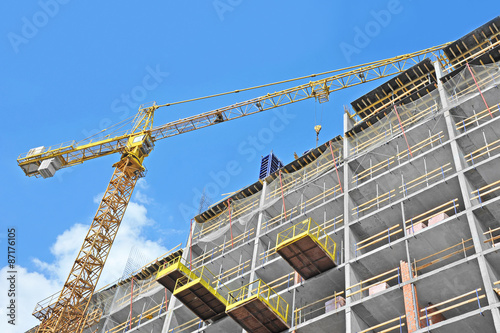 Crane and building construction site against blue sky © Unkas Photo