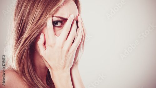 Afraid frightened woman peeking through her fingers