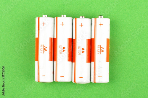 White AA batteries isolated on the green background
