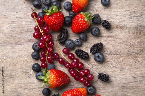 Fototapeta Naklejka Na Ścianę i Meble -  Some gooseberries, raspberries, strawberries and blueberries ove