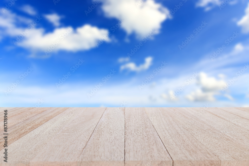 Top wooden table and blur of blue sky background Top wooden table and blur of blue sky background