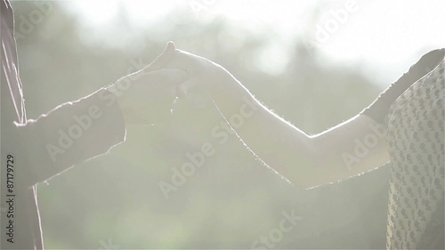 Young couple holding hand in hand in bright sunlight. Close-up photo