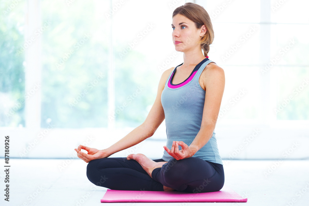 Young woman meditating in lotus pose.