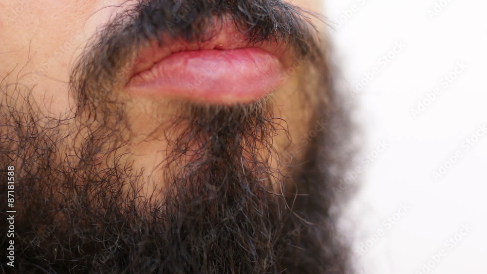 Man thinks stroking his black long beard on a white background Man thinks stroking his black long beard on a white background