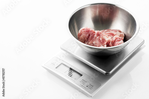 Meat in metal bowl on digital scale