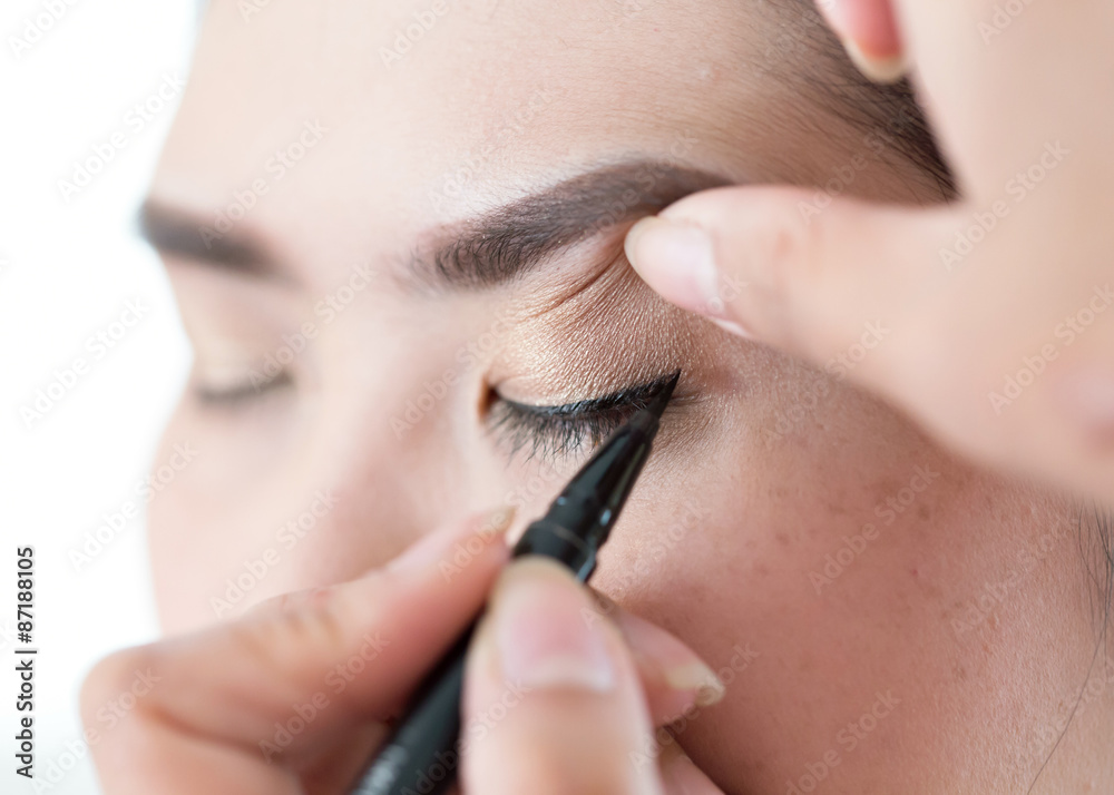 makeup beauty with brush eye liner on pretty woman