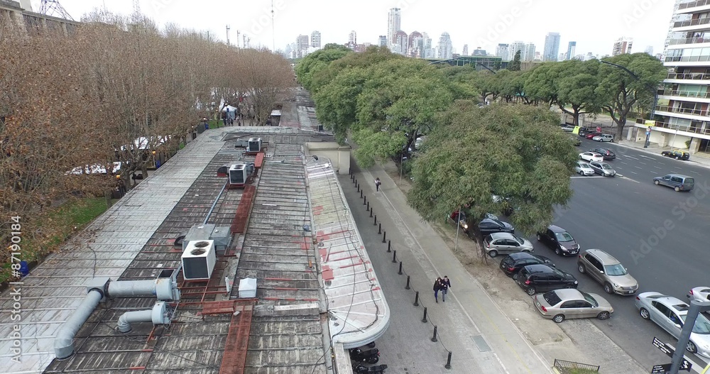 Escena aérea con dron de gran avenida. Movimiento de los coches, transporte público, peatones y camiones. Cámara se mueve hacia los lados desde el techo a la avenida. Buenos Aires.