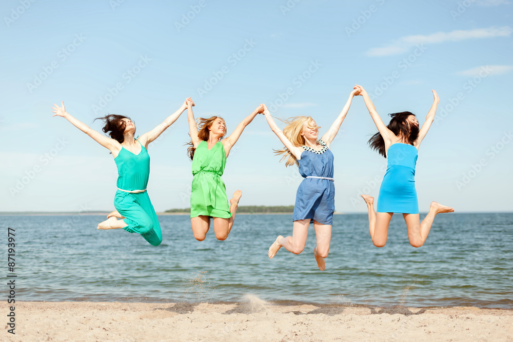 smiling girls jumping on the beach smiling girls jumping on the beach