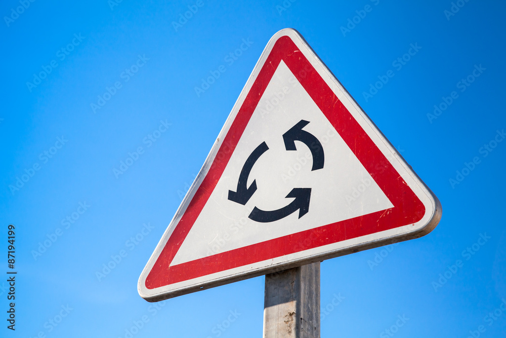 Traffic roundabout, triangle road sign and sky Traffic roundabout, triangle road sign and sky