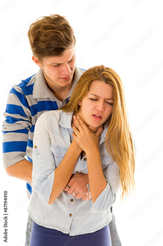 Couple Demonstrating First Aid Techniques By Man Performing Heimlich On Female Choking Foto De