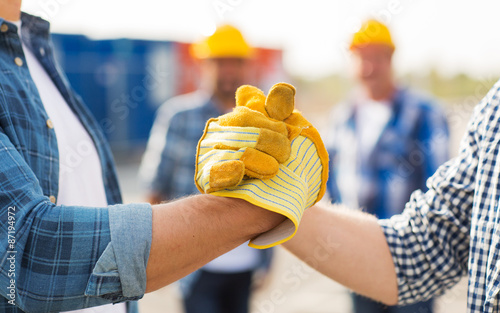 Photo close up of builders hands making handshake