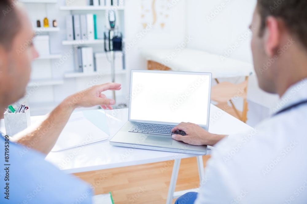 Concentrated medical colleagues working with laptop
