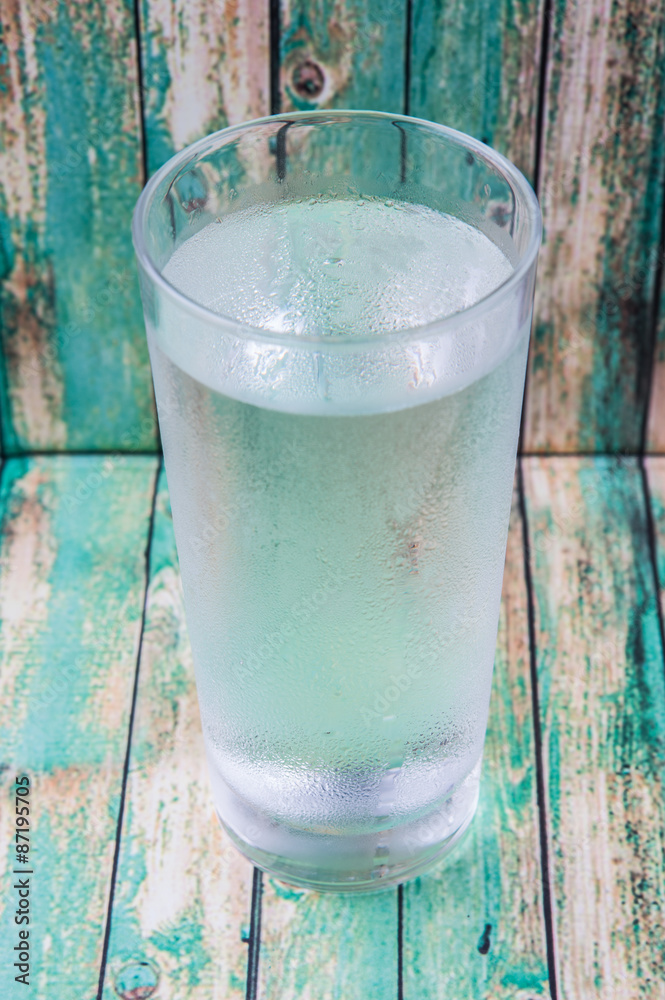 A glass of water over wooden background A glass of water over wooden background