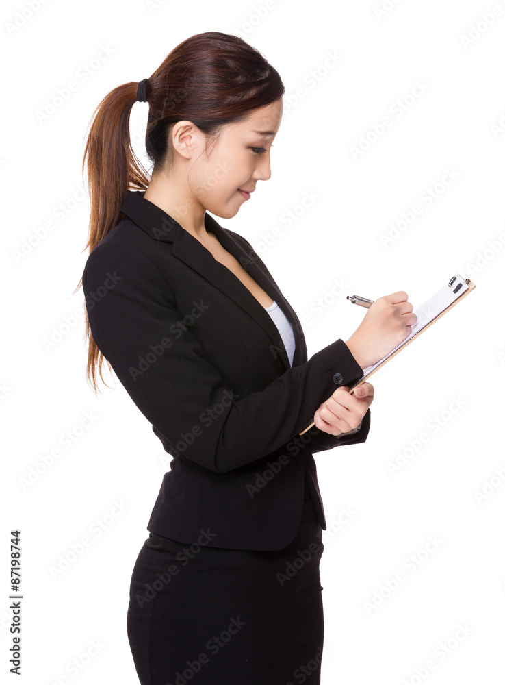Asian young businesswoman write on clipboard Asian young businesswoman write on clipboard