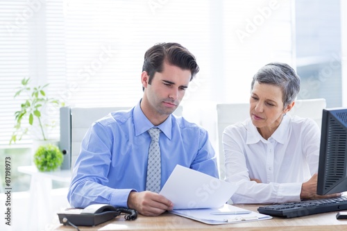 Two business people looking at a paper