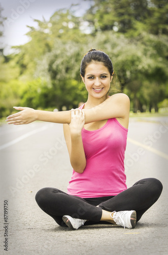 Hispanic brunette in yoga clothing sitting with legs crossed