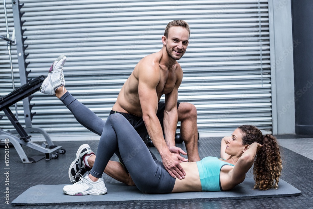 Muscular couple doing abdominal exercises Muscular couple doing abdominal exercises