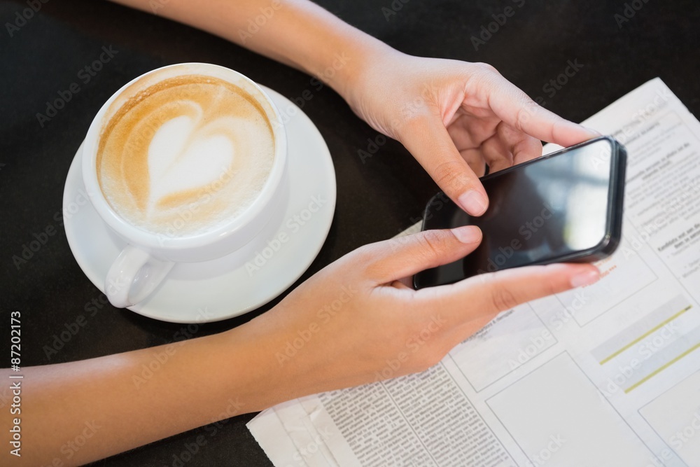 Fototapeta premium Coffee with a heart and hands holding a phone