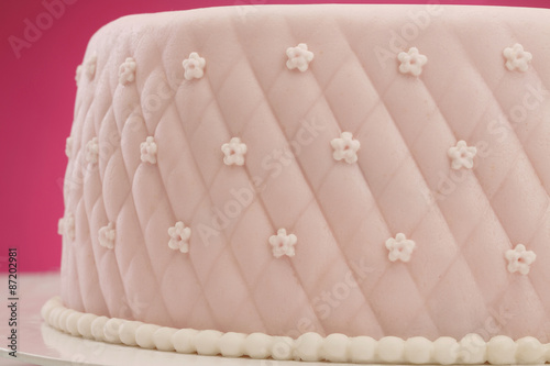 Cuadro en lienzo Decorative fondant pink cake on picnic table/ Pink background