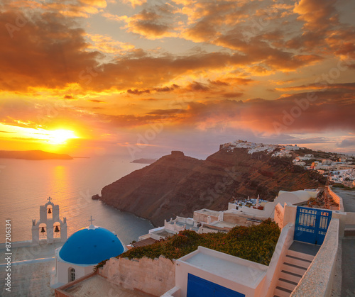 Santorini island with church against colorful sunset in Greece
