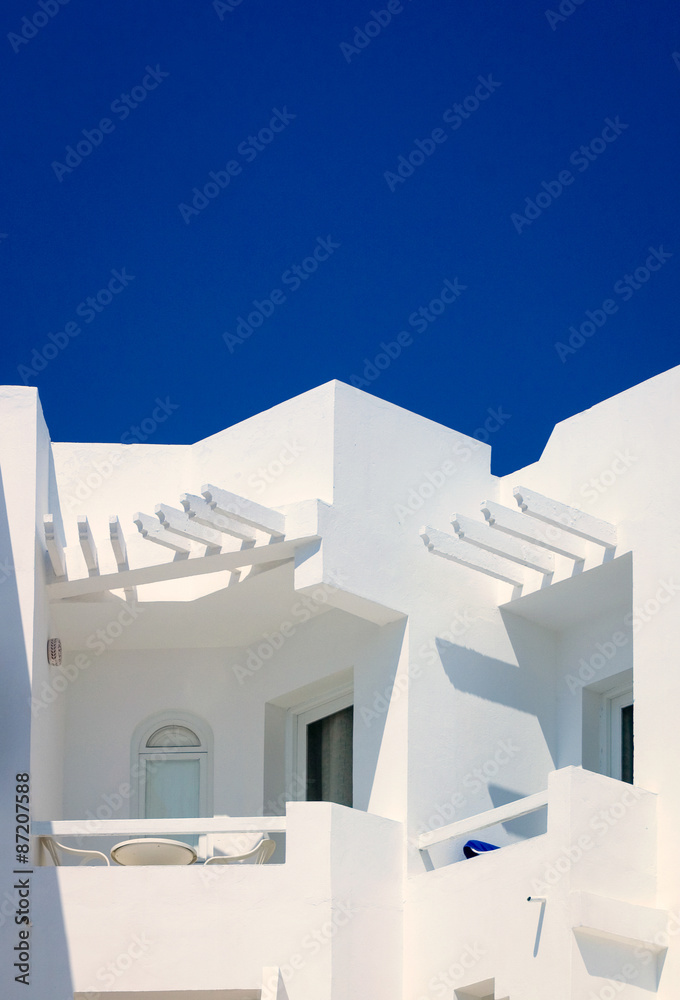 Mediterranean hotel balcony. Detail of a bright white contemporary hotel complex in Tunis, Tunisia, with a cloudless blue sky providing copy space.