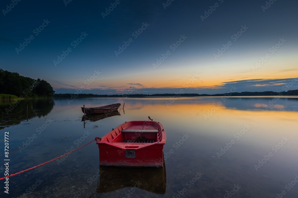Beautiful lake sunset with fisherman boat