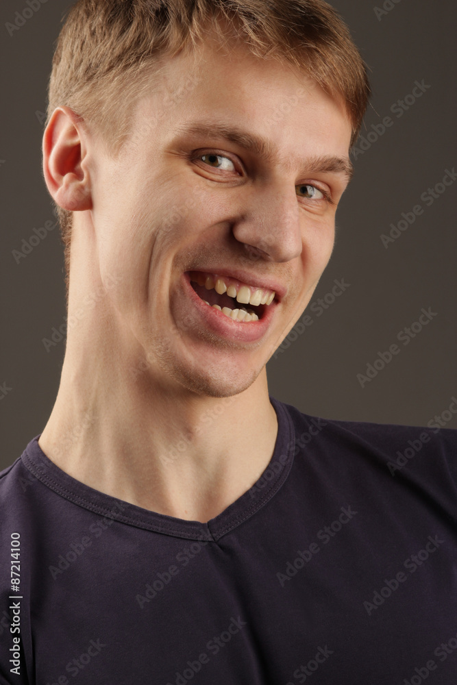 Fototapeta premium the handsome young man with a fair hair looks smiling