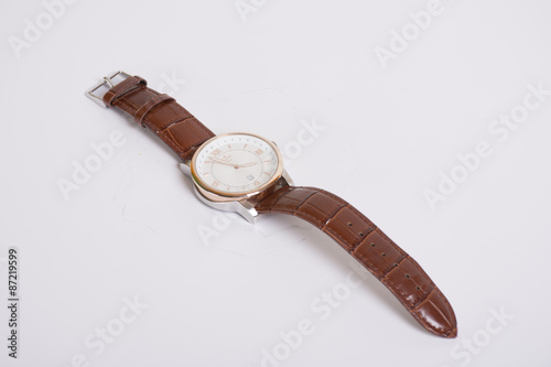 Wristwatch with brown letter on white background