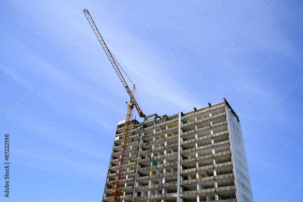 demolition of a skyscraper with a high crane demolition of a skyscraper with a high crane