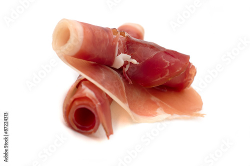 Two slices of parma ham roled positioned against each other photo