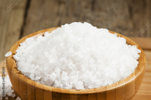 Large white sea salt in a wooden bowl, selective focus