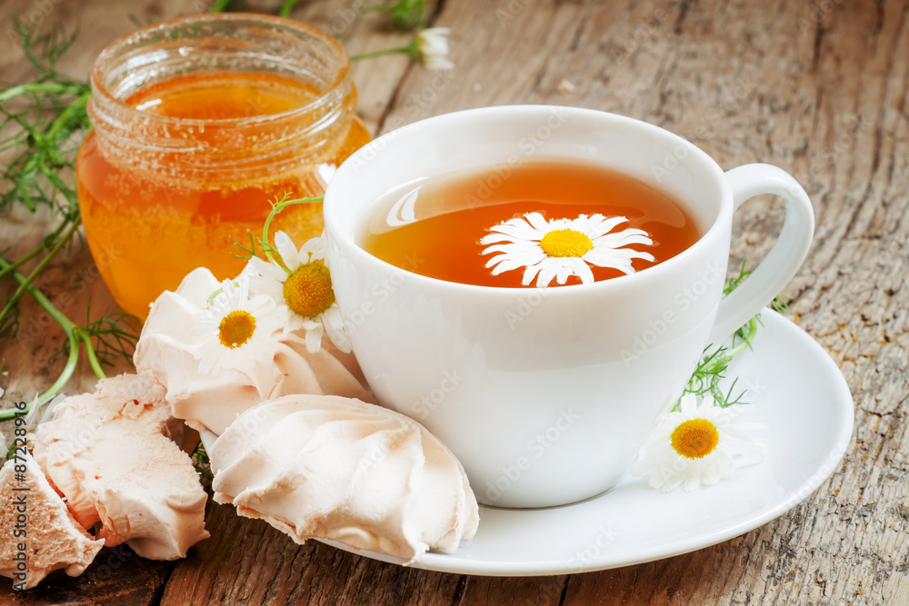 Black tea with chamomile, honey and marshmallow, selective focus Black tea with chamomile, honey and marshmallow, selective focus