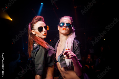 Two sexy girls in sunglasses. The club