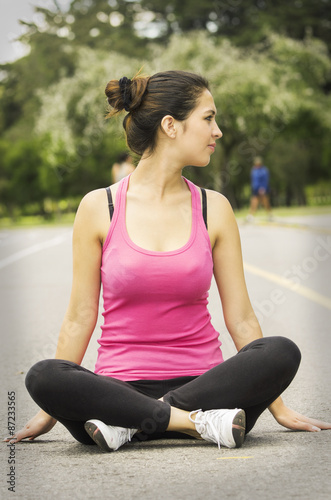 Hispanic brunette in yoga clothing sitting with legs crossed and